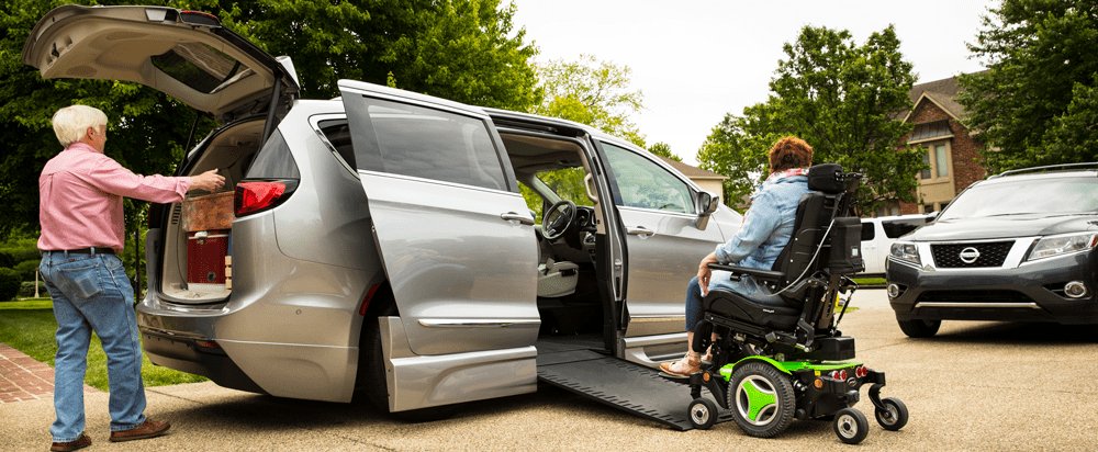 Wheelchair accessible van with ramp deployed and patient boarding